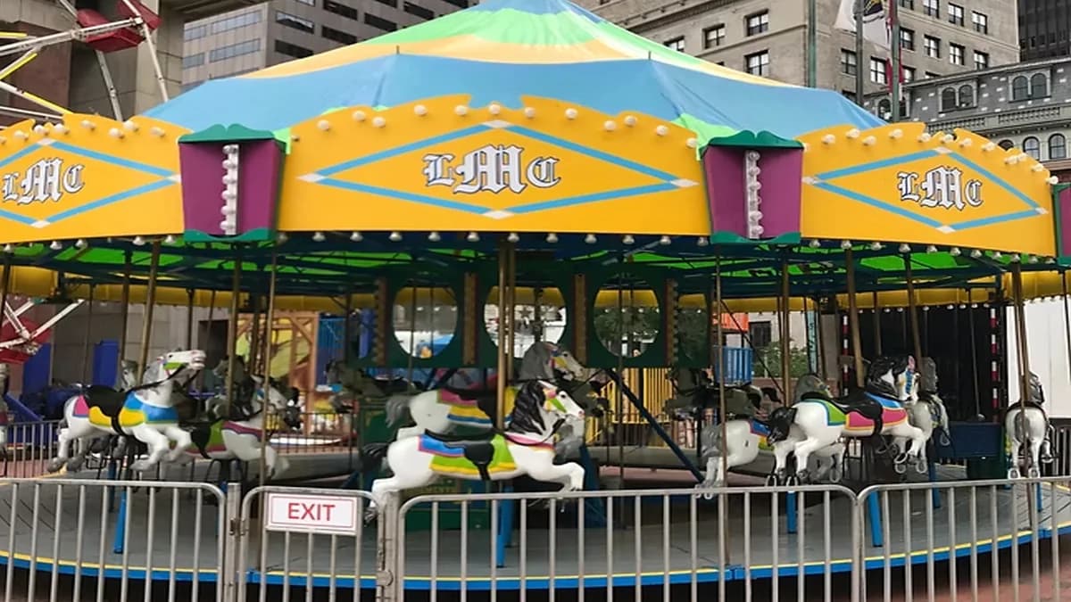 Classic carousel with painted horses under a yellow and blue canopy